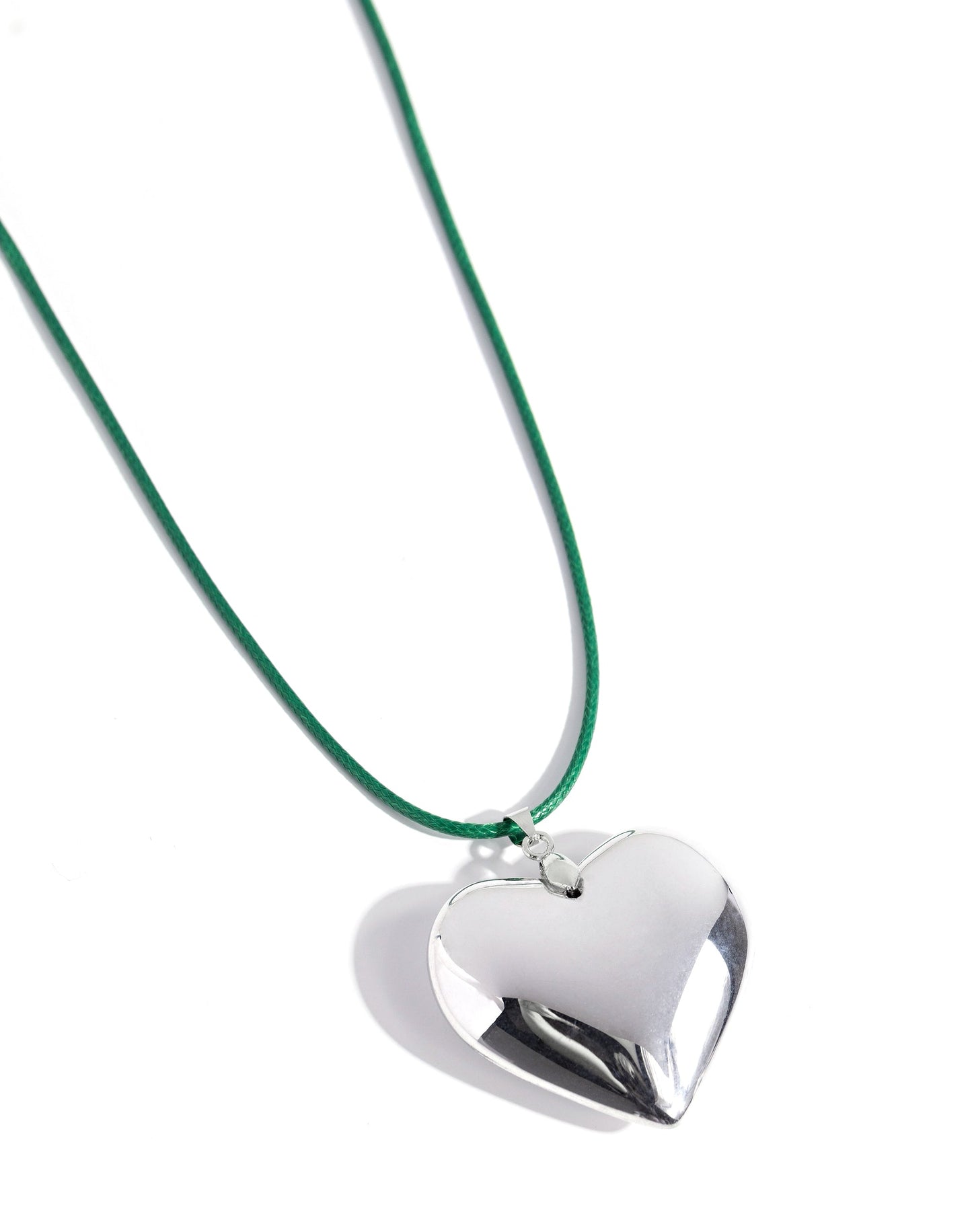 An oversized, sleek silver heart glides along a vibrant green cord, creating a flirtatious pendant below the collar. Features an adjustable clasp closure.
N2612